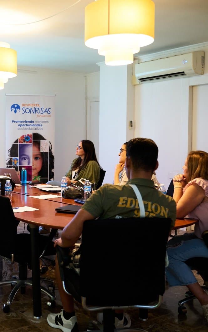 Participantes en un taller de la Fundación Despierta Sonrisas atienden a un formador frente a una proyección